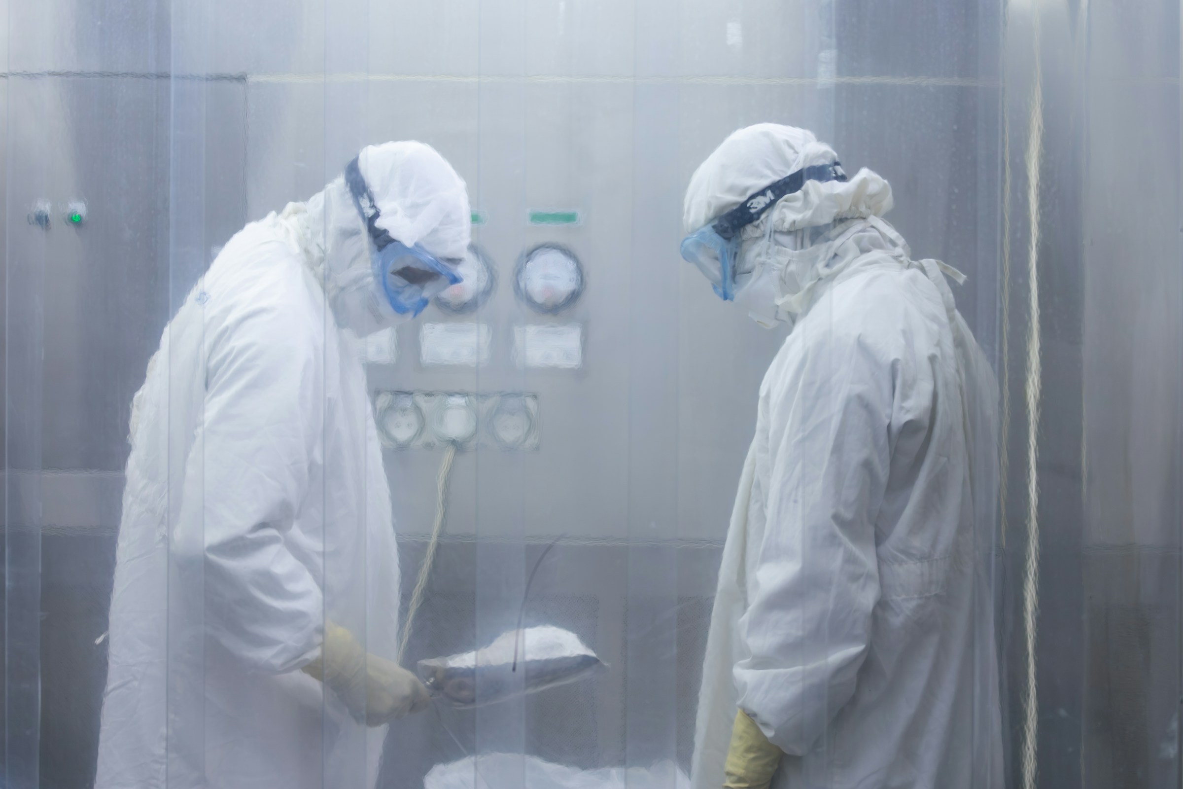 Scientists in protective gear working in a cleanroom facility